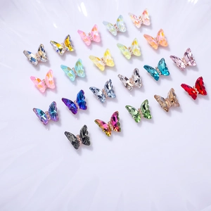 Macro shot of colorful 3D crystal butterfly nail charms with vibrant facets and gold centers