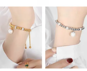 Detail of beaded bracelet with pearl pendant in gold and silver finish on wrist