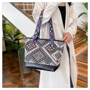 Detailed shot of ethnic tote bag featuring colorful geometric patterns and black base