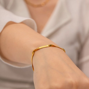 Detail of 18K gold plated stainless steel snake chain bracelet worn on a female wrist