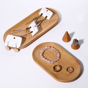 Oval solid wood jewelry tray with ring cone and bracelets in a minimalist home display
