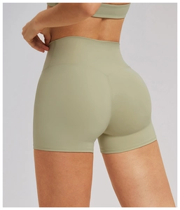 Close-up of cross waist detail and peach lift stitching on green yoga shorts