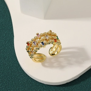Vintage layered gold open ring with colorful rectangular zircons on a white tray