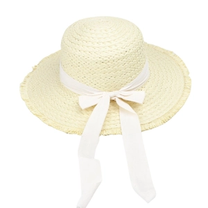 Detailed macro of a light beige straw sun hat with frayed edges and a white bow ribbon