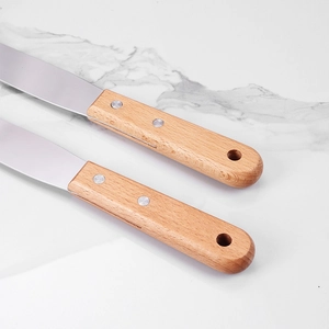 Detailed shot of ergonomic beech wood handles with hanging holes on stainless steel spatulas