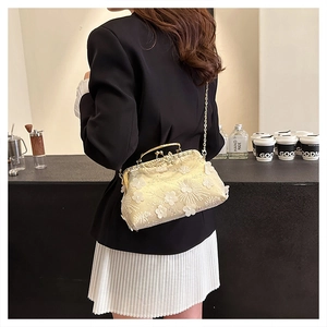 Detail of 3D floral embroidery on off-white evening clutch with gold metal chain