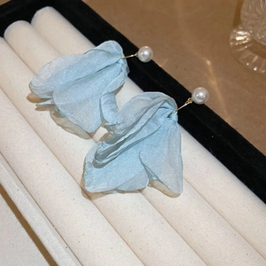 Detailed macro of light blue chiffon flower earrings with white pearl studs