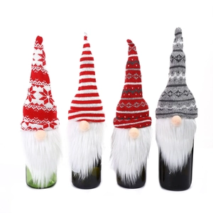 Set of four knitted gnome wine bottle covers for Christmas table decoration