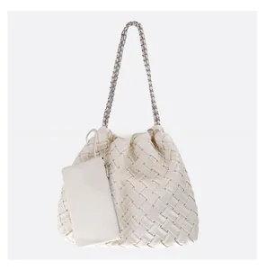 Detail of white woven leather tote bag with metal chain strap and matching coin purse