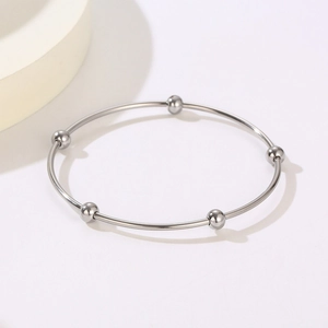 Macro view of silver titanium steel bangles with five fixed minimalist beads