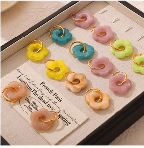 Detailed display of colorful resin flower earrings on a beige jewelry display tray