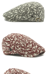 Detail of retro floral flat caps in gray-green and burgundy with adjustable metal buckles