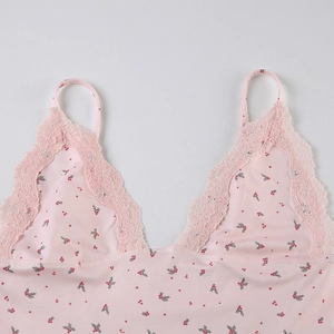 Détail d'un caraco rose à imprimé fleuri avec bordures en dentelle et fines bretelles