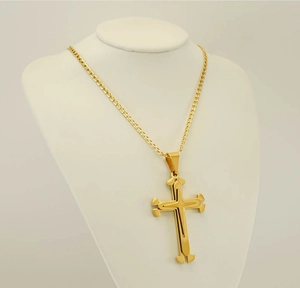 Detailed view of multilayered 18k gold plated stainless steel cross pendant on mannequin