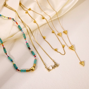 Colliers avec pendentif cœur doré et chaîne en perles colorées sur soie élégante