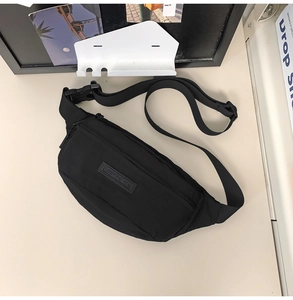 Close-up of minimalist black waist bag with adjustable strap and durable buckle details