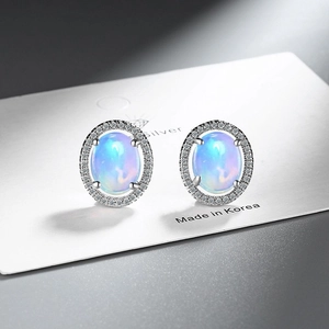 Elegant silver oval opal stud earrings surrounded by brilliant zircon accents on display