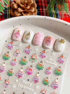Macro shot of 3D embossed Christmas nail stickers with gold trees and snowflakes