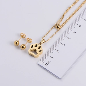 Gold hollow paw print pendant necklace and ball stud earrings set with measurement ruler