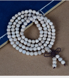 Macro detail of 108 camphor wood prayer beads with traditional Chinese knot and tassel