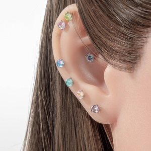 Delicate rose-cut 4mm zircon stud earrings in various colors worn on a female ear