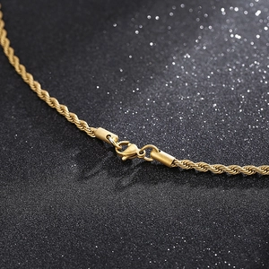 Makroaufnahme einer goldenen Kordelkette mit Karabinerverschluss und Metalloberfläche