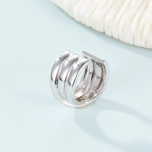 Close-up of three-layer silver geometric ear cuffs with minimalist polished metal finish