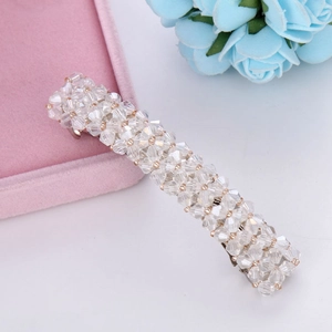 Close-up of sparkling crystal beads on a gold metal spring hair clip for women