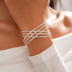 Close-up of sparkling layered geometric rhinestone crossover bracelet worn on a wrist