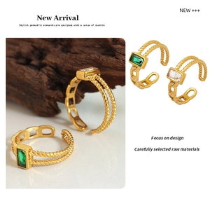 Close-up of titanium steel gold ring featuring emerald-cut stones and twisted rope texture