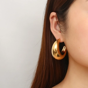 Fashionable oversized hollow crescent C-shape earrings plated in 18K gold on model