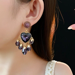 Detailansicht von Vintage-Ohrringen mit lila Kristallherzen und Wassertropfen-Quasten am Model