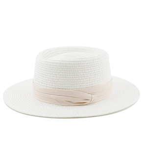Detailed view of white flat top straw hat featuring a light beige fabric ribbon trim