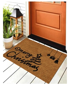 Detail of Christmas doormat with Merry Christmas print and holiday icons on wood floor