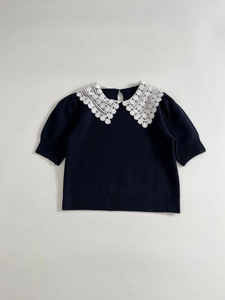 Detail of the white floral lace Peter Pan collar on this navy blue knitted short sleeve top