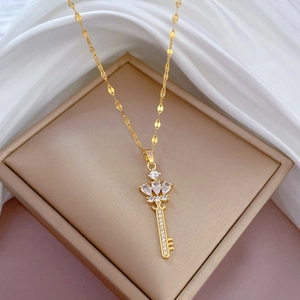 Elegant gold titanium crown key necklace with sparkling crystals in a jewelry box