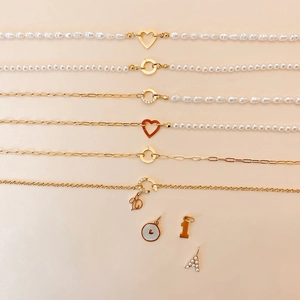 Détail de divers colliers en perles d'eau douce et chaînes dorées avec breloques DIY