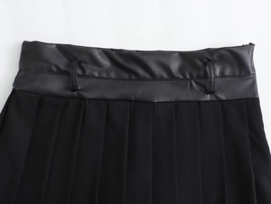 Detail of black faux leather waistband and pleated fabric texture on stylish skorts