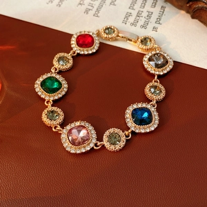 Detail of vintage gold bracelet with colorful gemstones and pavé crystal accents