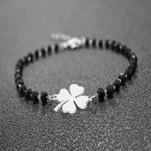 Cross obsidian beaded bracelet featuring a silver clover charm and adjustable clasp