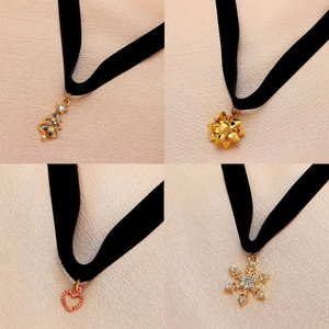 Detail of Christmas velvet chokers set featuring golden tree, bow, heart and snowflake pendants