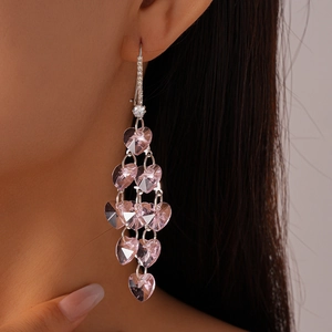 Détail d'une boucle d'oreille pendante avec cœur en cristal rose et monture argent