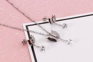 Detailansicht eines silbernen Schmetterlings-Schmucksets mit Zirkonia auf rosa Grund