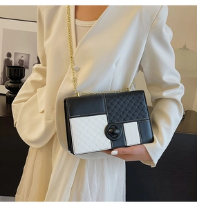 Detail of black and white quilted PU leather handbag with chain strap and twist lock