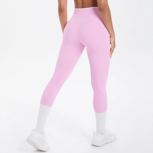 Vue arrière du legging de yoga rose taille haute montrant l'effet galbant et passepoil blanc