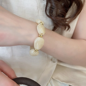 Detailed close-up of chunky irregular acrylic oval bead bracelet with gold metal spacers