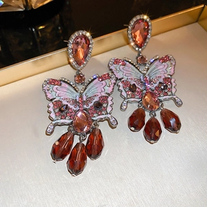 Detail of luxury butterfly tassel earrings with crystals and sparkling star-light effects