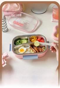 Three-compartment stainless steel bento box with a cartoon bunny lid and colorful meals