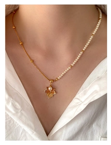 Detail of maple leaf pendant with gradient crystals and asymmetric pearl chain necklace