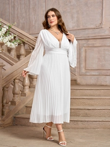 Dettaglio di un abito a pieghe in chiffon bianco con eleganti maniche a campana e scollo a V